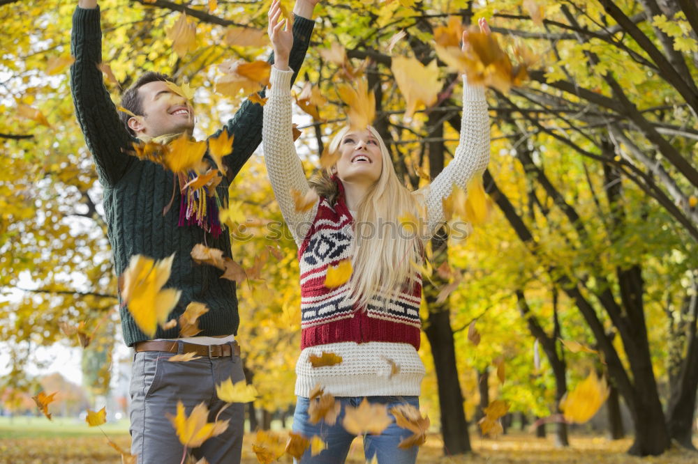 Similar – Couple makes a leaf fight in autumn