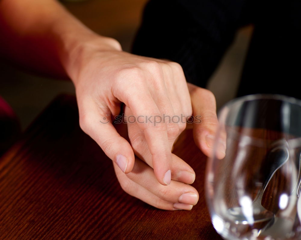 Similar – On a table there is a bottle of alcohol and a shot glass. A person’s hand is holding the shot glass.