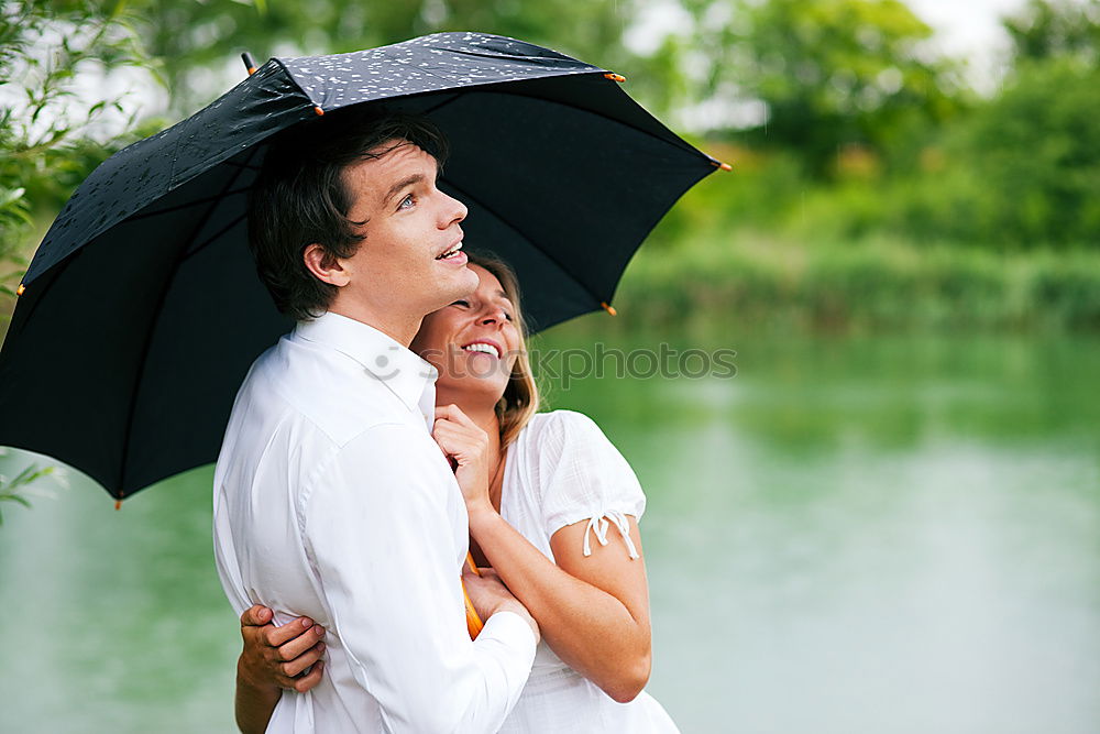 Similar – Young couple looking at each other under umbrella outdoors