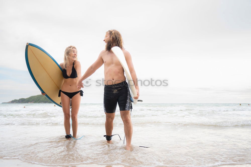 Similar – Aerial view of a surfing couple laying on the beach