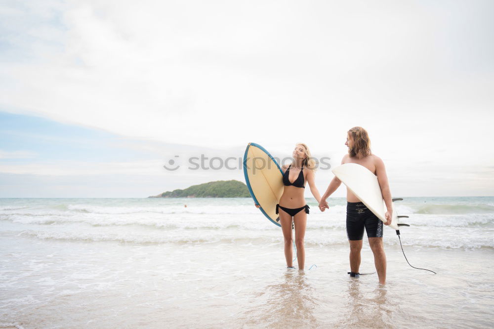 Similar – Image, Stock Photo Two happy girlfriends having fun at the beach with surfboards