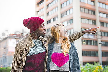 Interracial young couple taking pictures to each other and having fun