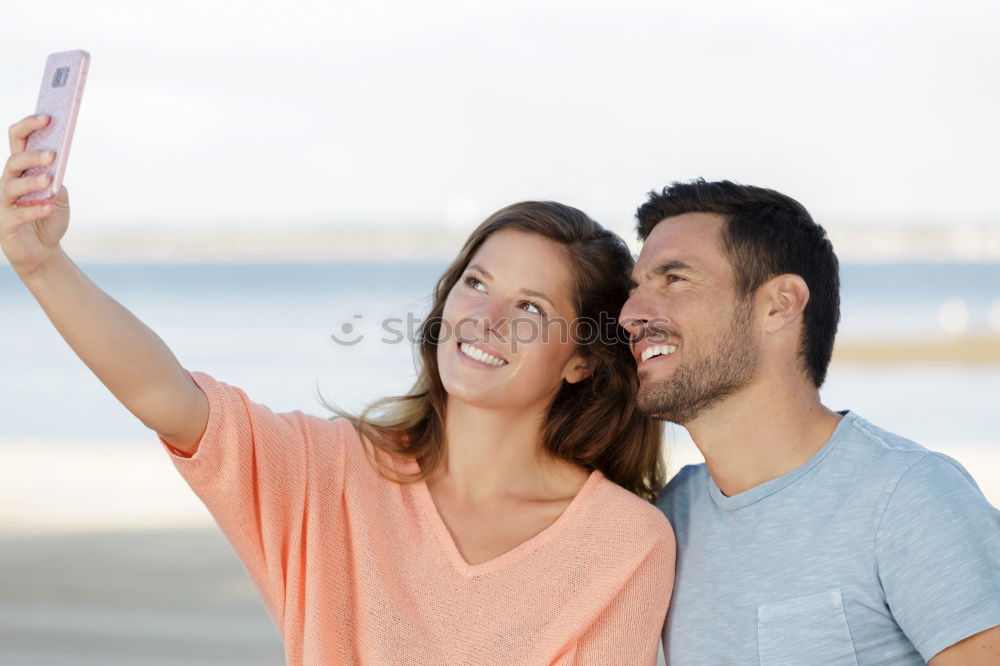 Similar – Happy young man and woman in fashionable sunglasses taking cellphone selfie on background of defocused blue sea. Vacation photos