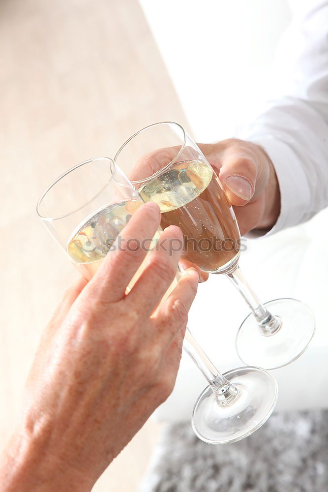 Foto Bild Schöne Frauenhände halten Gläser mit Champagner oder Rosenwein. Nahaufnahme. Frauen stoßen mit Gläsern an. Neujahrsfeier, Veranstaltung oder Party. Weichzeichner. Menschliche Hände. Vertikale Aufnahme