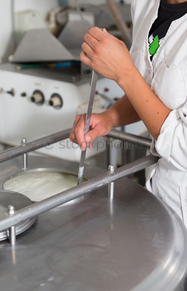 Similar – Image, Stock Photo A cook in a restaurant wearing a mask as a precaution against the coronavirus preparing the meal.