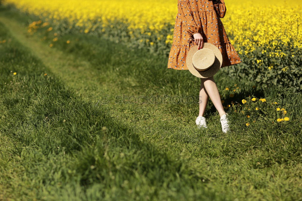 Similar – analogue portrait of a young woman sitting barefoot in a rye field in a summer dress and smiling