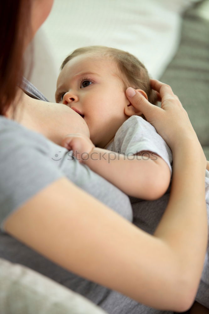 Similar – Image, Stock Photo Young mother breast feeding her baby at home