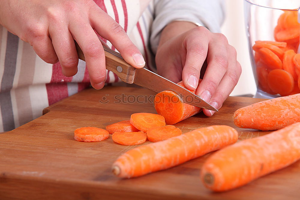 Similar – process of cutting slices of carrot on a kitchen board