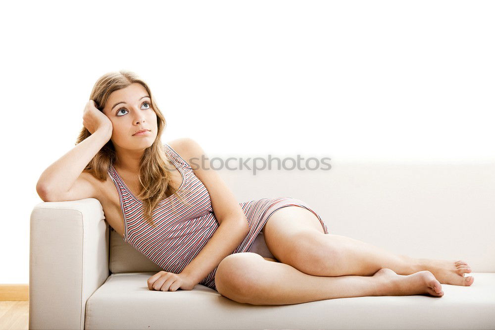 Similar – young, tall, long-legged woman stands barefoot with bare legs in front of a light sofa and looks into the camera