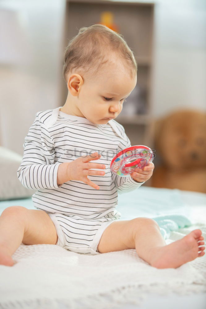 Similar – Baby toddler sits interested and curious in front of washing machine on the floor