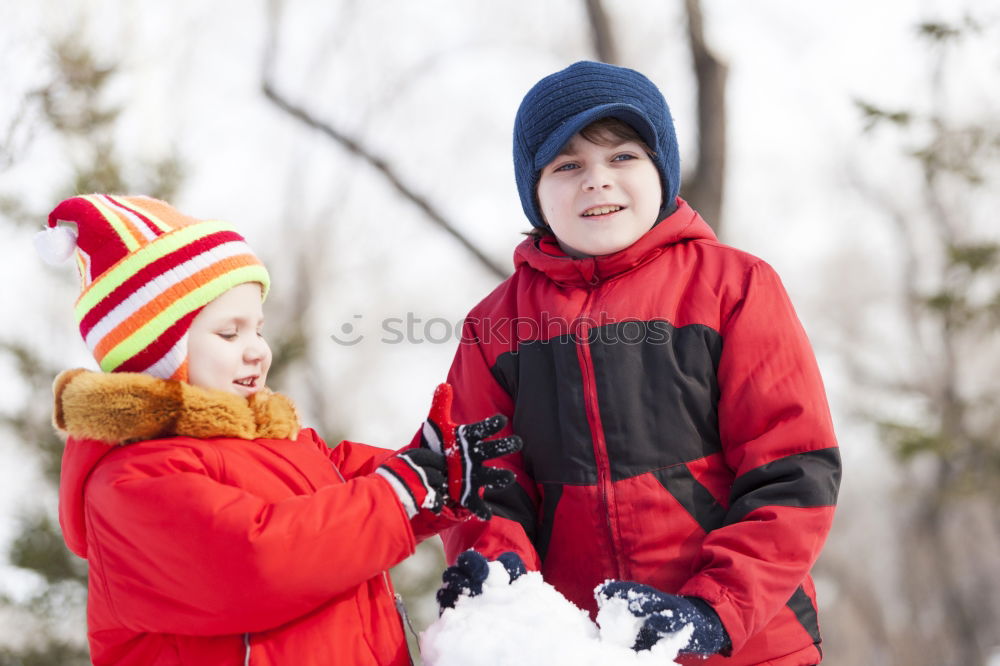 Similar – Two adorable young brothers outdoors in winter wrapped up warmly against the chill weather with the older boy cuddling his toddler sibling on his lap