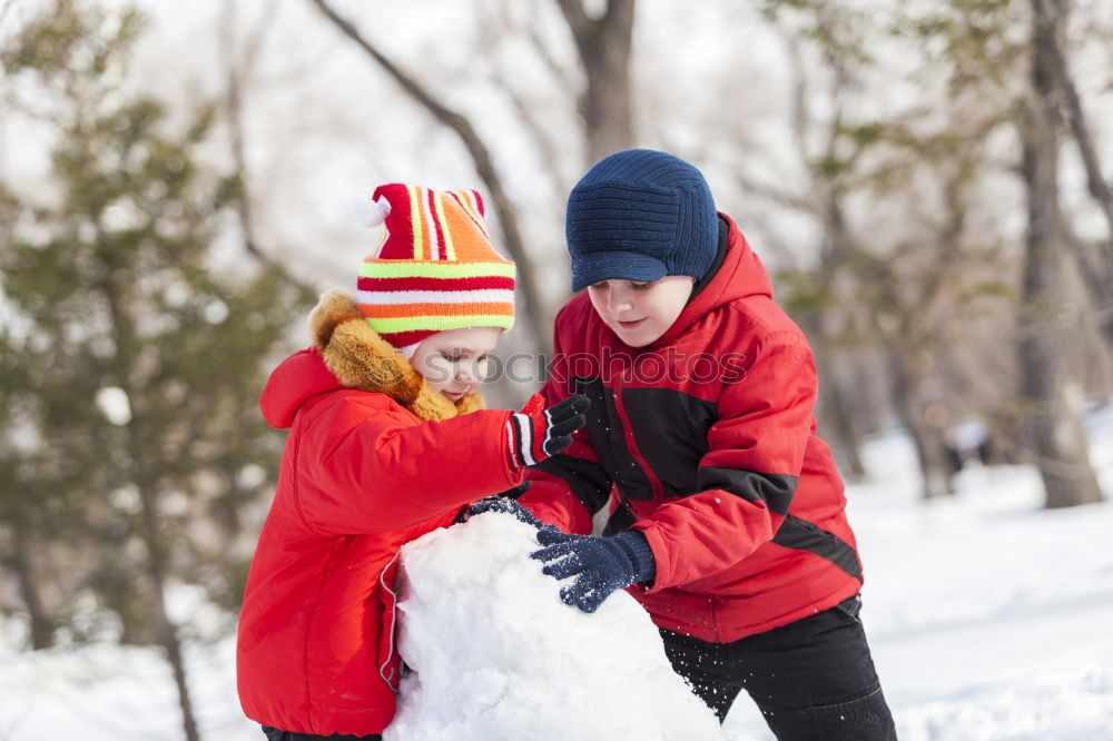 Similar – Girl and her little sister making a snowman