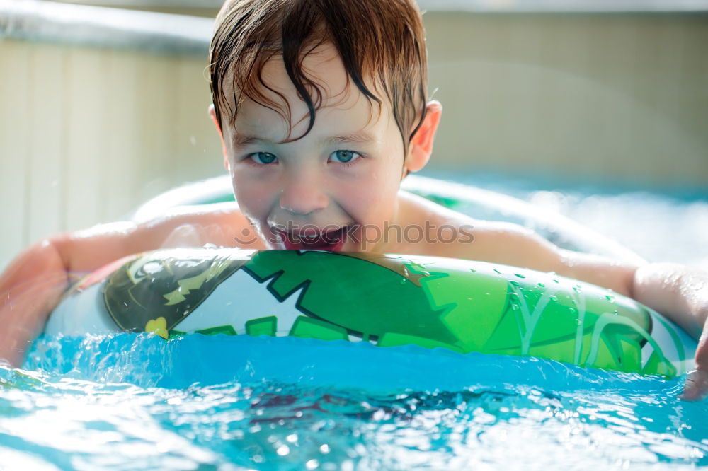 Similar – Image, Stock Photo Young boy in inflatable tube swimming with a big smile on his face