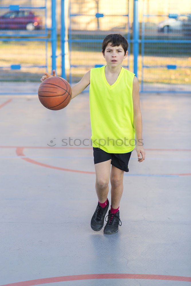 Teenage playing basketball on an outdoors court