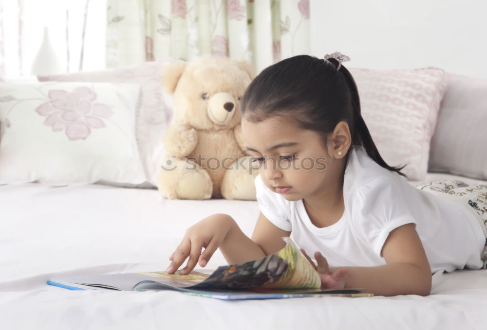 Similar – Image, Stock Photo Little girl doing homework on bed at home