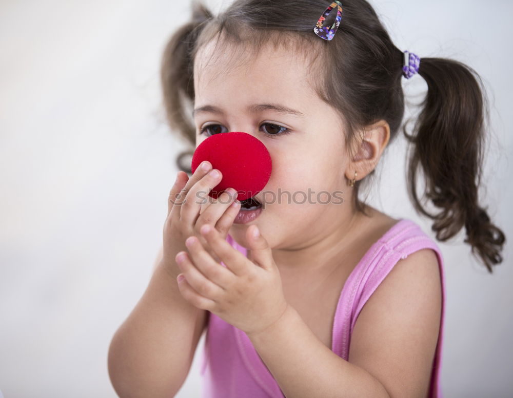 Similar – Girl with clown nose looks into the camera