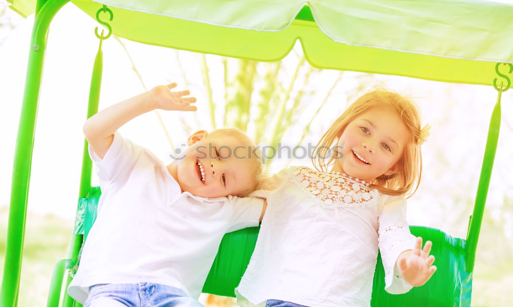 Similar – Cute caucasian siblings sitting on slide on playground