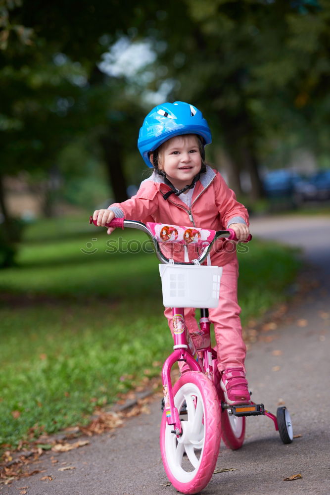 Similar – Image, Stock Photo Little girl with security helmet sitting in bike seat