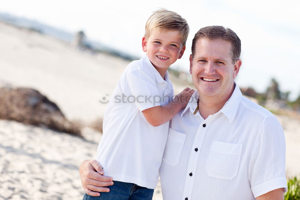 Similar – Image, Stock Photo Smiling father with his young son at the beach crouching down on the sand with a smile as the boy stands alongside him