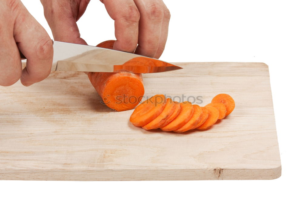 Similar – process of cutting slices of carrot on a kitchen board