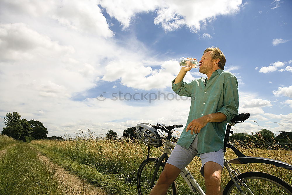 Similar – man with an e-bike looks at a road map