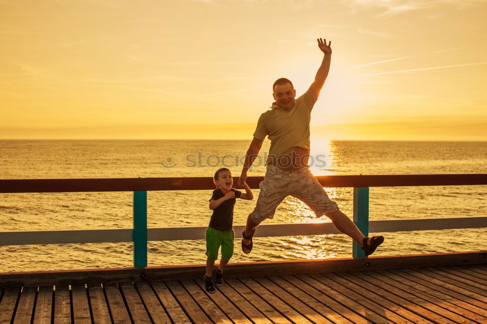 Similar – Father and son playing on the beach at the sunset time.