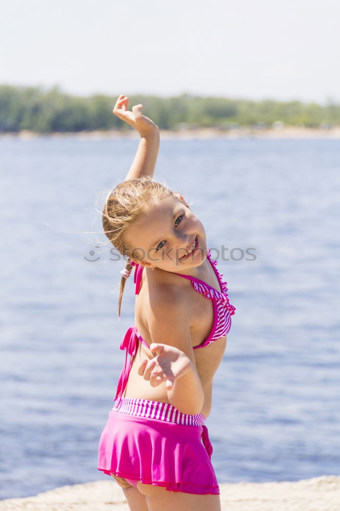 Playful girl standing in pier near lake