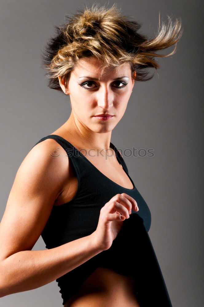 Image, Stock Photo Close up front portrait of one young athletic woman in sportswear in gym over dark background, standing in boxing stance with hands and fists, looking at camera