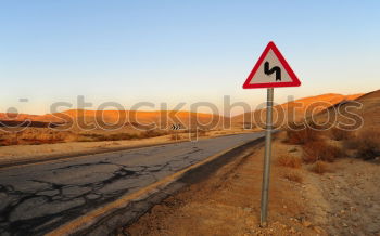 Warning sign in curve in front of alpine panorama