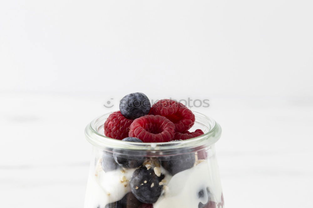 Similar – Berry-fruity water, iced with raspberries, blueberries, ice cubes and drinking straw on white background