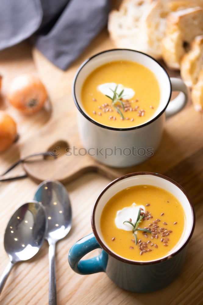 Fresh pumpkin soup in three bowls on a wooden table