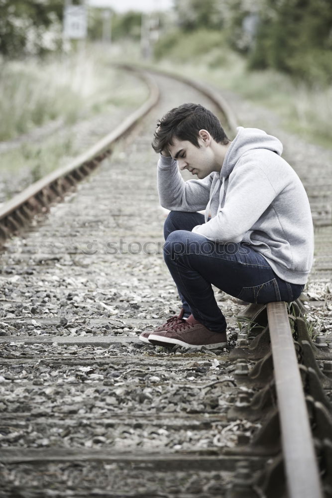 Similar – Sad girl teenager sitting on rusty rail track outside the town. Escape to be alone