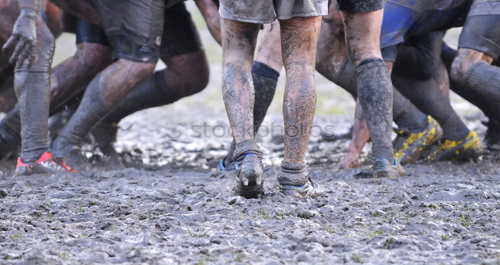 Similar – Legs in red trousers and green rubber boots jumping in a muddy puddle, so that the mud flies up