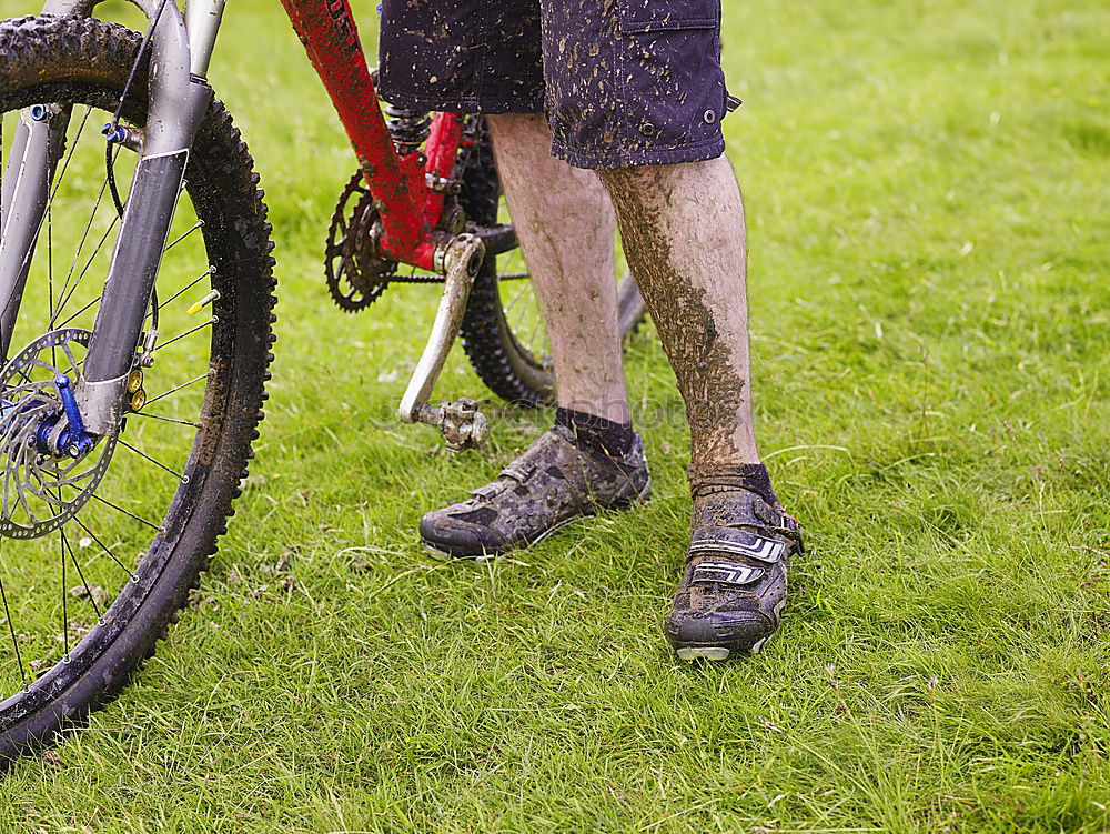 Similar – Legs in red trousers and green rubber boots jumping in a muddy puddle, so that the mud flies up