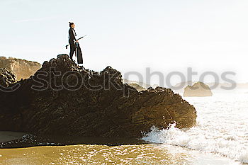 Similar – Man sitting on fence in rocky coast