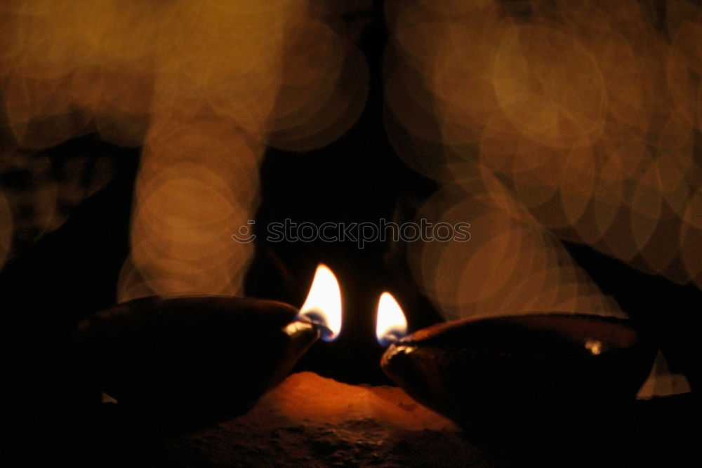 Similar – Image, Stock Photo many church candles with varying degrees of burn stuck in the sand in the dark. selective focus. dripping wax from one candle.