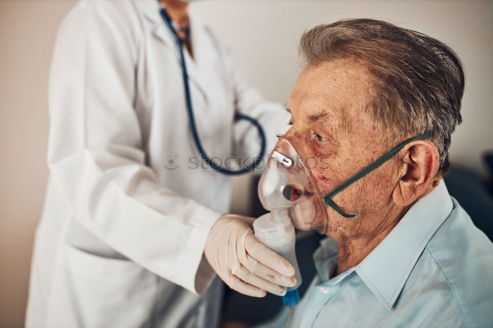 Doctor holding syringe with vaccine and making injection to senior patient. Covid-19 or coronavirus vaccine