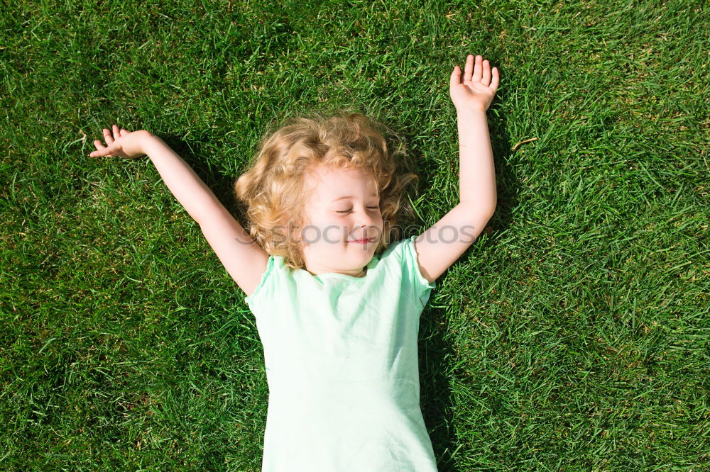 Image, Stock Photo Funny, funny, cheerful, happy, funny blonde girl outside in the garden, looks up and stretches both arms up to the tree. Little joker does nonsense, sticks out her tongue, in nature, in the park under the tree.