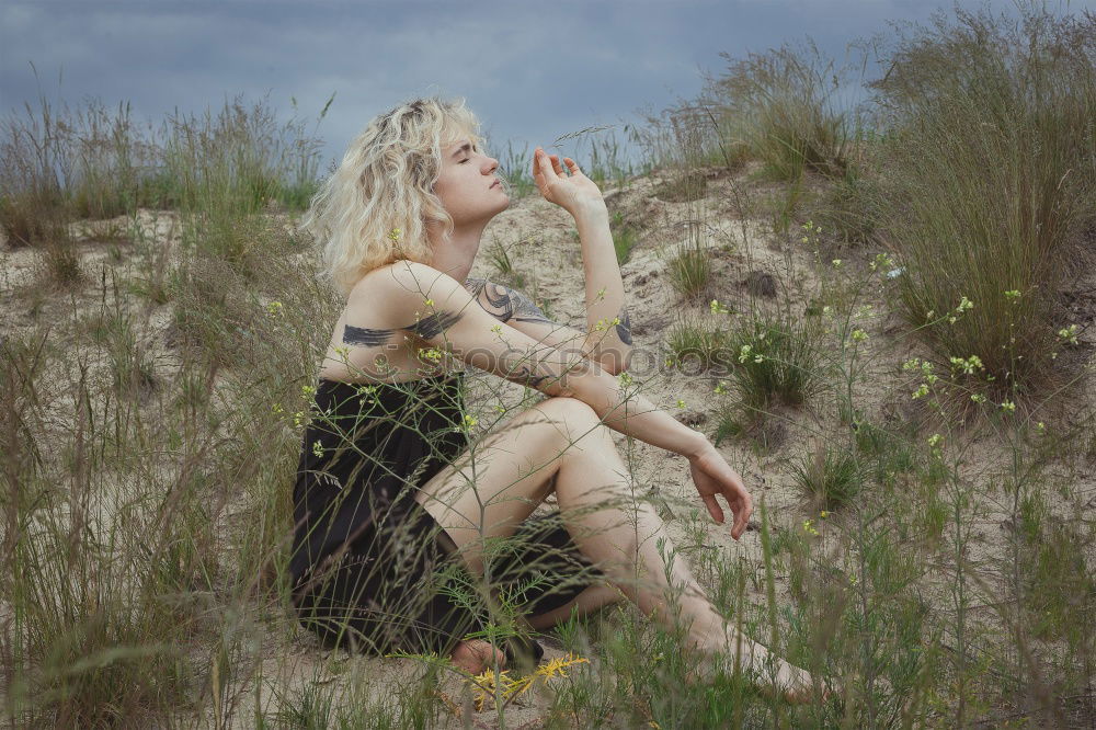 Similar – Young woman with turquoise hair sits barefoot in forest on beach and laughs loudly