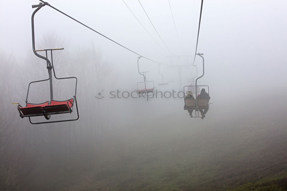 Similar – Chairlift with empty 2-seater chair and view of snow-free hill country