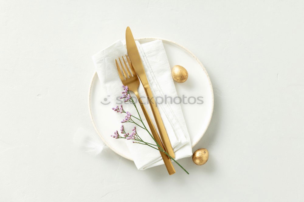 Festive golden cutlery knife and fork spoon in a white bottle