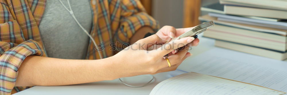 Similar – Woman hands using smartphone and writing notebook