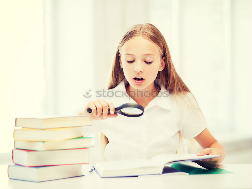 Similar – Schoolgirl reading a book in classroom