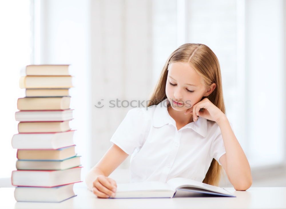 Similar – Schoolgirl reading a book in classroom