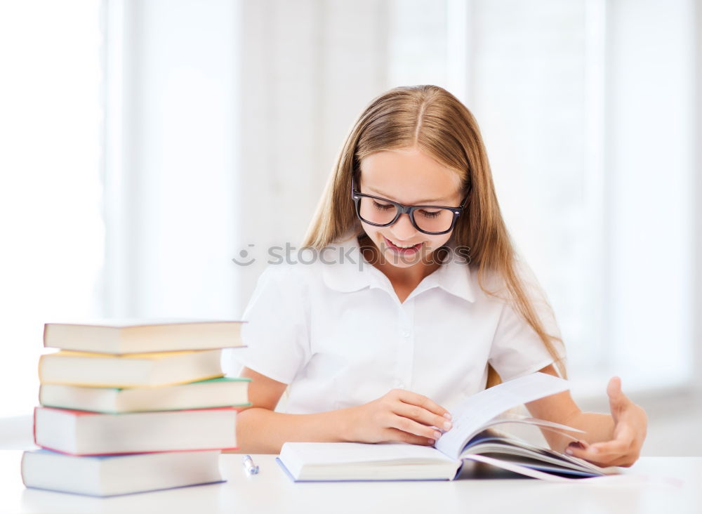 Similar – Schoolgirl reading a book in classroom