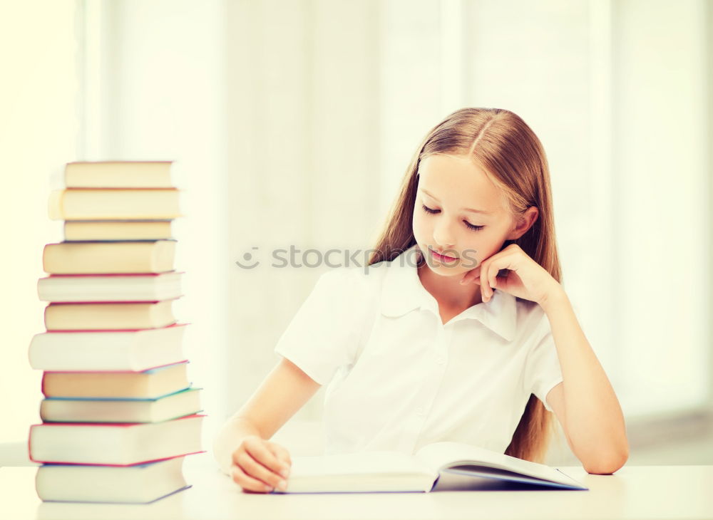 Similar – Schoolgirl reading a book in classroom