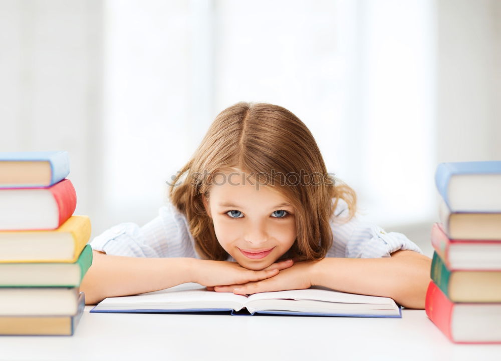 Schoolgirl reading a book in classroom