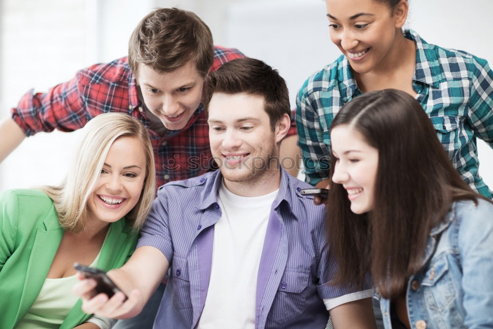 Similar – Multiracial group looking at a tablet computer outdoors