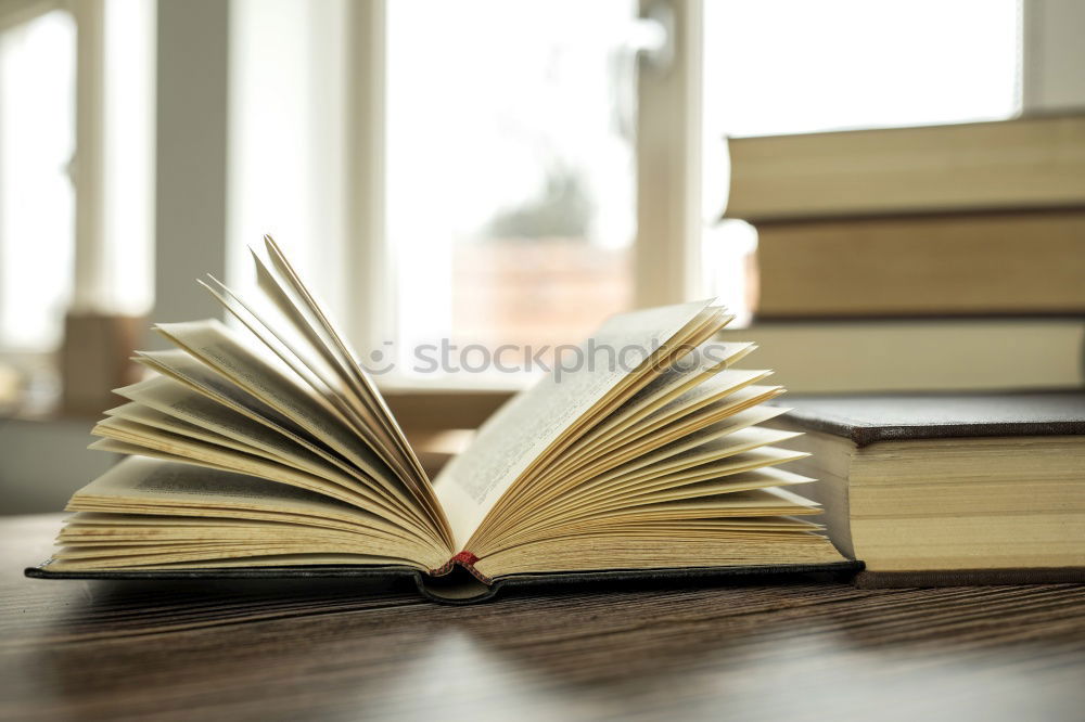 Similar – Woman turning pages of book on table in antique bookstore