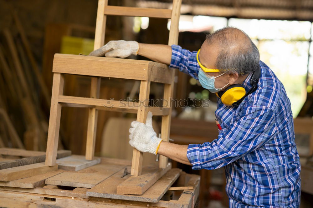 Image, Stock Photo Carpenter using belt sander. Carpenter sanding a wood